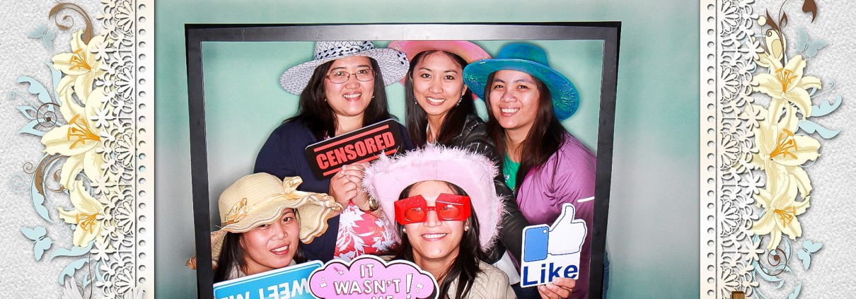 Ladies wearing hats and holding photo booth signs