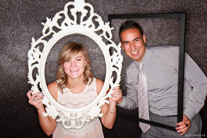 Sweet couple having fun in the photobooth and playing with picture frames