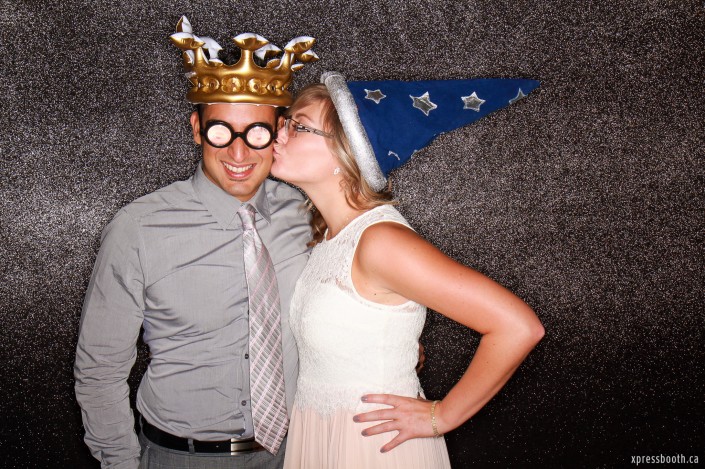 Kissing couple wearing wizard hat, crown and bottle glasses